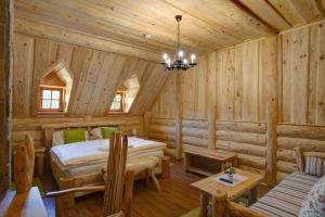a log cabin bedroom with a bed and a couch at Srub u Medvěda in Nový Jičín