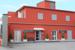 a red building with a bench in front of it at Bed and Breakfast Aereoparking in Naples