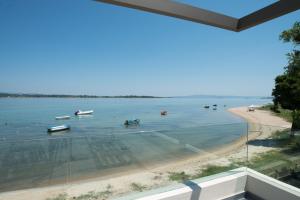 a view of a beach with boats in the water at Tiamo Secrets Beach Front by TravelPro - Vourvourou Halkidiki in Vourvourou