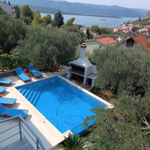 a swimming pool with chairs next to a house at Apartment Ivka in Klek