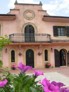 a building with a balcony and a clock on it at Villa Clementine in Piazza Armerina