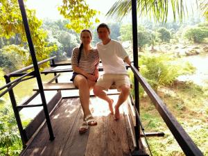 a man and a woman sitting on a wooden platform at Riverview Adventure Resort in Kitulgala +3 photos