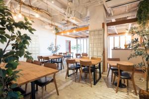 a room with wooden tables and chairs and plants at Hotel Grand Plaza Urashima in Kurihara