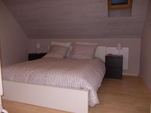 um quarto com uma cama branca com duas mesas de cabeceira em Het Zolderhuis em Arendonk