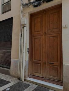 a large wooden door on the side of a building at Larios Rooms in Málaga +3 photos