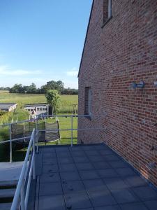 een bakstenen gebouw met een oprit naast een veld bij Het Zolderhuis in Arendonk