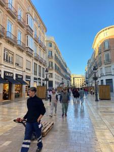 a group of people walking down a city street at Larios Rooms in Málaga