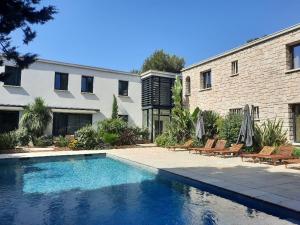 a swimming pool in front of a building at HPC Suites - Cassis Centre - Parking Securisé et Piscine Chauffée in Cassis
