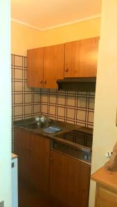 a kitchen with wooden cabinets and a stove at Residence Mirage in Oga