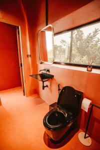 a bathroom with a black toilet and a sink at C South Hideout in Butong +20 photos