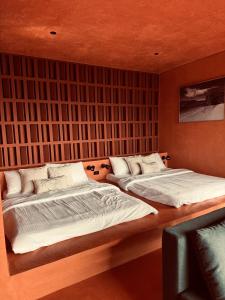 two beds in a bedroom with a wall at C South Hideout in Butong