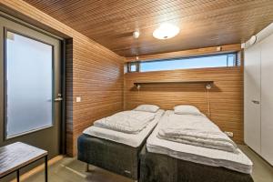 a bedroom with two beds in a room with a window at Villa Solarsuite Incl WiFi, Jacuzzi for extra fee in Himos