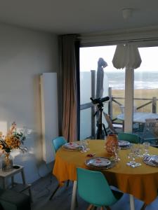 a dining room with a table and a view of the ocean at La Naturelle Duplex 90 in Wimereux +49 photos
