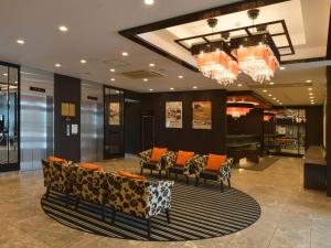 a lobby with couches and a chandelier at APA Hotel Gifu Hashima Ekimae in Hashima