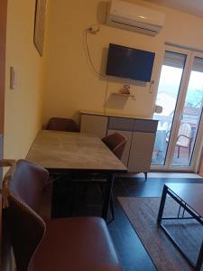 a dining room with a table and a tv at Una Apartments in Budva