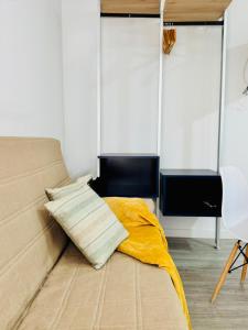 a bedroom with a bed with a yellow blanket at ALAUDAE Apartamentos Parking Gratis plazas limitadas in Mérida