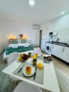 a room with a table with plates of food on it at ALAUDAE Apartamentos Parking Gratis plazas limitadas in Mérida