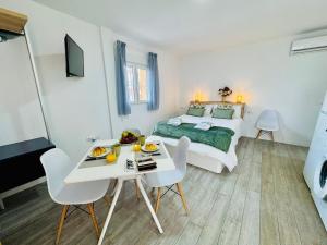 a bedroom with a bed and a table and chairs at ALAUDAE Apartamentos Parking Gratis plazas limitadas in Mérida