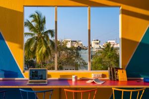 a table with a laptop on it in front of a window at goSTOPS Bengaluru, Gandhi Nagar Majestic - Private Rooms & Dorms in Bangalore