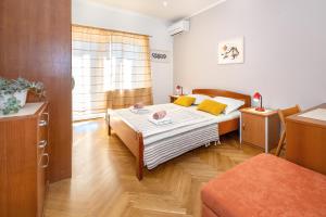 a bedroom with a bed with yellow pillows at Double Rooms Jasna with Sea View in Baška