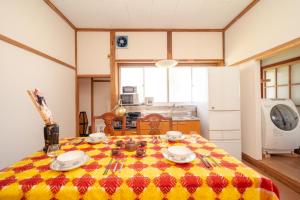 a kitchen with a table with a yellow and red blanket on it at Wakamizu Minpaku in Tōgane