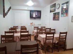 a dining room with tables and chairs and a tv at Residencial Moeda in Coimbra +121 photos