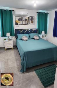 a bedroom with a blue bed with green curtains at Simpsons Little Gem 2 in Kingston +42 photos