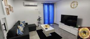 a living room with a couch and a flat screen tv at Simpsons Little Gem 2 in Kingston