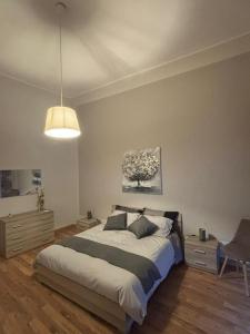 a bedroom with a large bed and a chair at Downtown Living in Catania