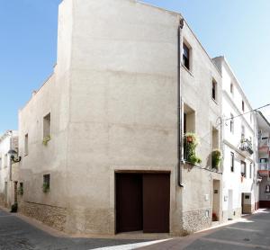 a large white building with a garage on a street at Cal Vibo in Vilabella