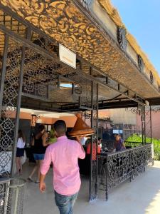 a man walking past a food truck with a tray on top at Fekhara CC in Marrakesh