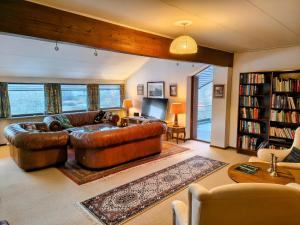 a living room with a leather couch and a tv at Sæbygaard Estate Kalundborg in Ruds-Vedby