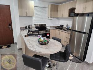 a kitchen with a table with a bowl of fruit on it at Simpsons Little Gem 1 in Kingston