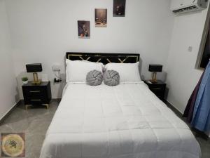 a bedroom with a large white bed with two night stands at Simpsons Little Gem 1 in Kingston +49 photos