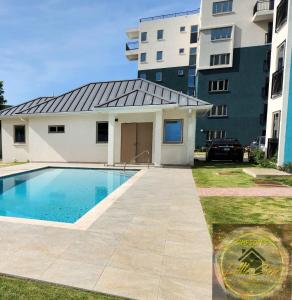 a house with a swimming pool in front of a building at Simpsons Little Gem 1 in Kingston