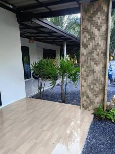 an open patio with a wooden floor and plants at Lanta Maikaew Guesthouse in Ko Klang +5 photos