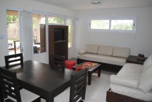 un salon avec une table et un canapé dans l'établissement Médano 29 Departamentos en alquiler, à Las Gaviotas 10 autres photos