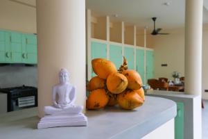 a pile of fruit sitting on a counter next to a statue at Allude Villa Weligama in Weligama
