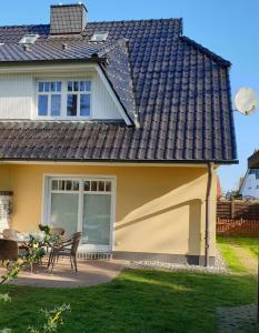 a house with a pitched roof and a patio at Strandstr 4b "Likedeeler 2" in Zingst