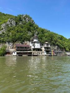 a building on the side of a mountain on the water at Vikendica Dunav i SAVA in Donji Milanovac