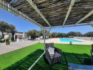 a patio with two chairs under a pergola at Borgo Rurale Cares in Dorgali