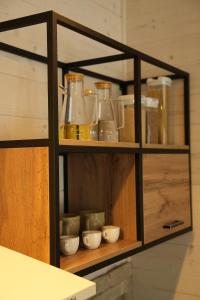 a wooden shelf with jars and bowls on it at Легіт in Khashchovanoye +30 photos