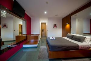 um quarto com uma cama e uma televisão em Motel Bracancún em Aveleira