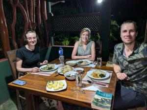 a group of people sitting at a table eating food at Blue Sapphire Safari Lodge, Udawalawe in Udawalawe +44 photos