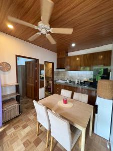 a kitchen with a wooden table and a ceiling fan at Sonnenblume Homestay in General Luna