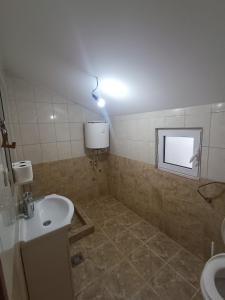 a bathroom with a sink and a light on the wall at Una Apartments in Budva +26 photos