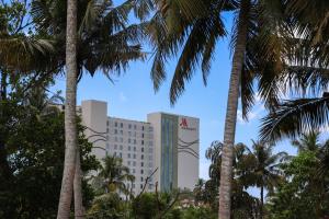a hotel with palm trees in front of it at Allude Villa Weligama in Weligama