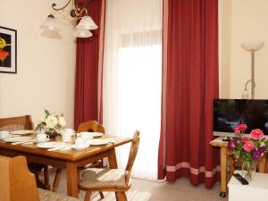 a living room with a table and a television at Landhaus Zehentner in Saalbach-Hinterglemm