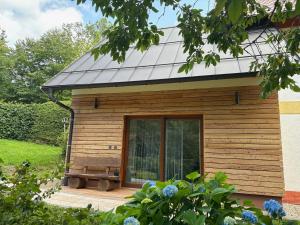 a wooden cabin with a bench on a deck at Selina in Janske Lazne +12 photos