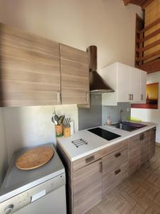 a kitchen with white cabinets and a counter top at Maison de Vacances Rayons de soleil in Notre-Dame-de-Monts